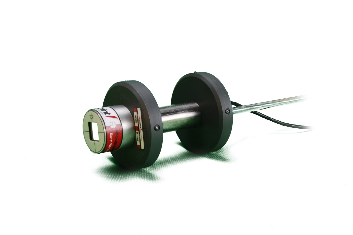 Microgage Bore Receiver Large Disks Dumbbell-shaped industrial rotor with two black weights on a metal shaft and a trailing cable on a white background.